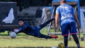 Persepolis players celebrating a goal during an AFC Champions League match at Azadi Stadium, illuminated by bright lights and surrounded by cheering fans.