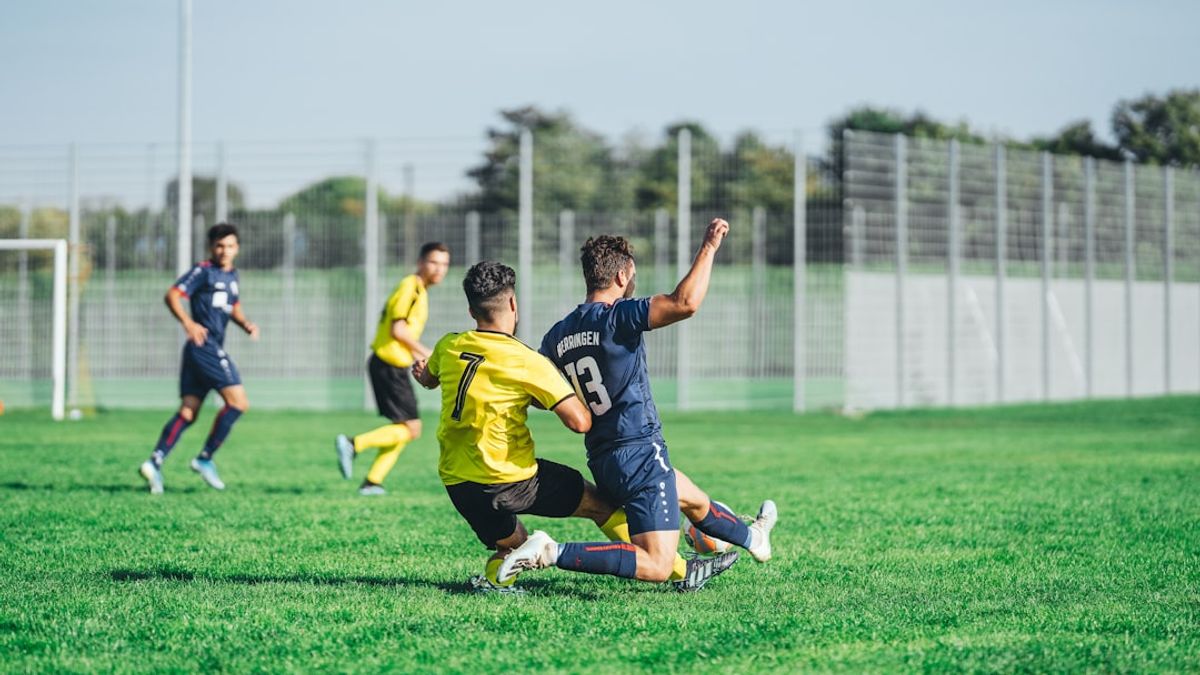 An aerial view of a vibrant football stadium in Iran during a match, with fans cheering in the stands.