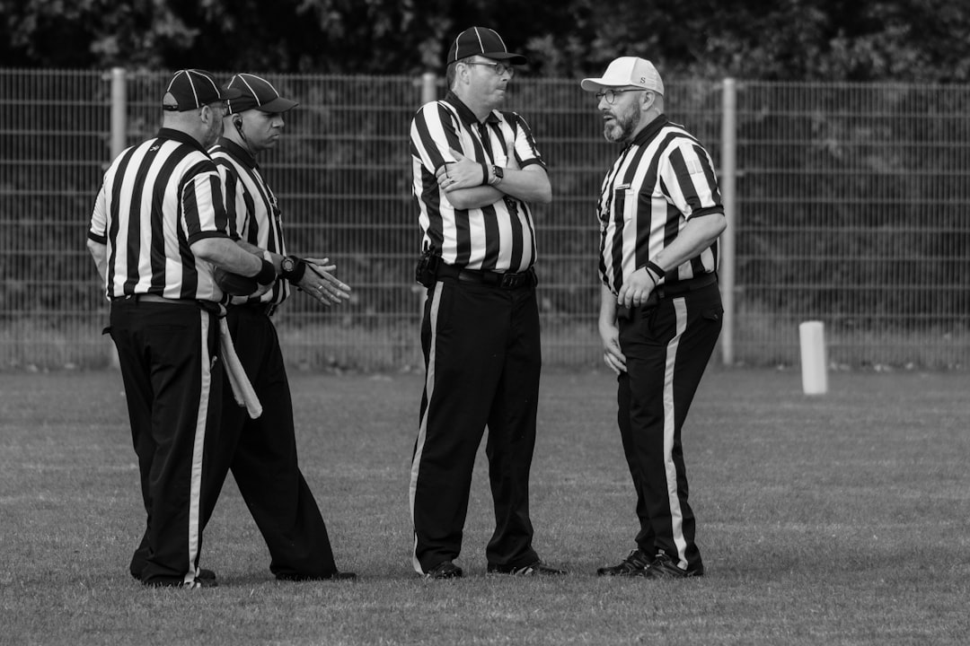 Football referees on the pitch demonstrating VAR and semi-automated offside technology in action