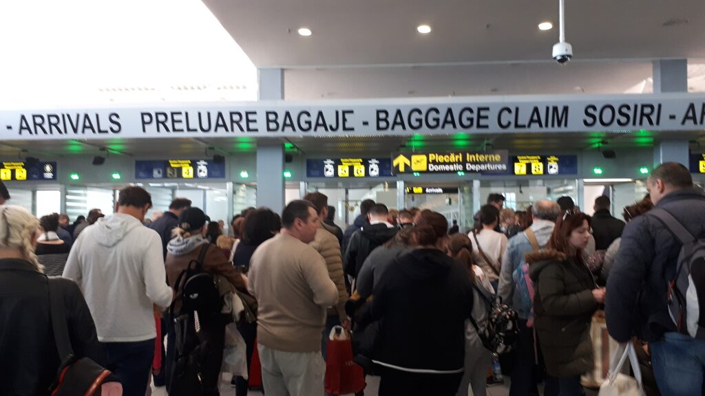 A row of passport control booths in an airport arrivals hall with queue markings