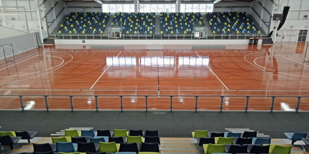 An indoor futsal court with painted lines, small goals and a polished wooden floor