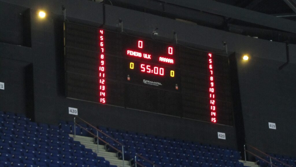 An electronic scoreboard above a competition arena showing bout numbers and times