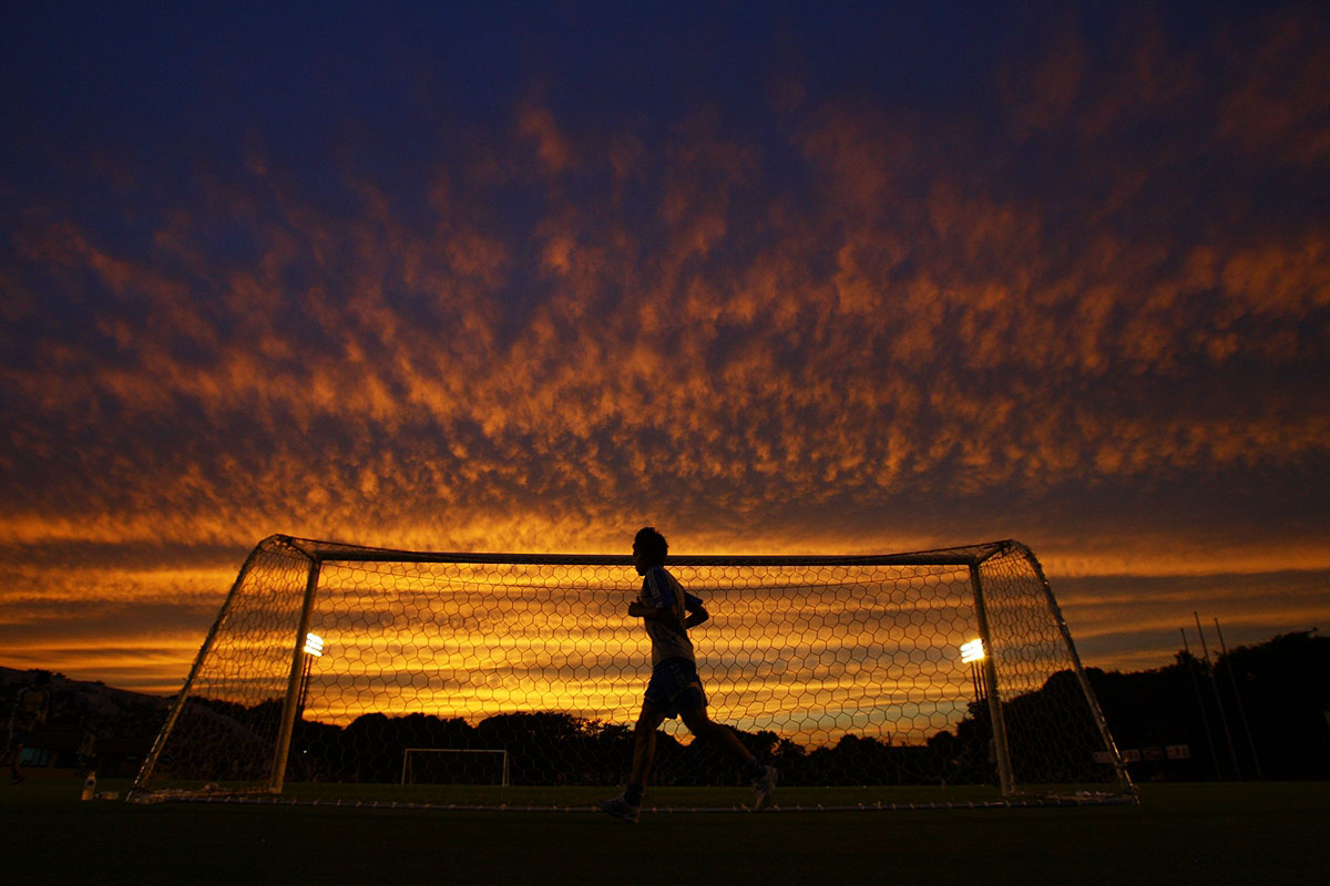 A group of players spread across a training pitch working through a drill with a coach