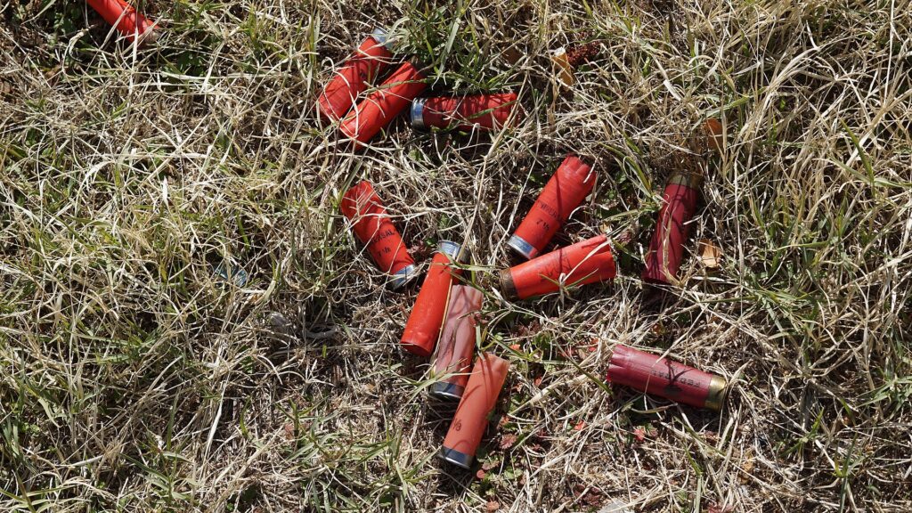 A paper shooting target with grouped bullet holes near the centre rings