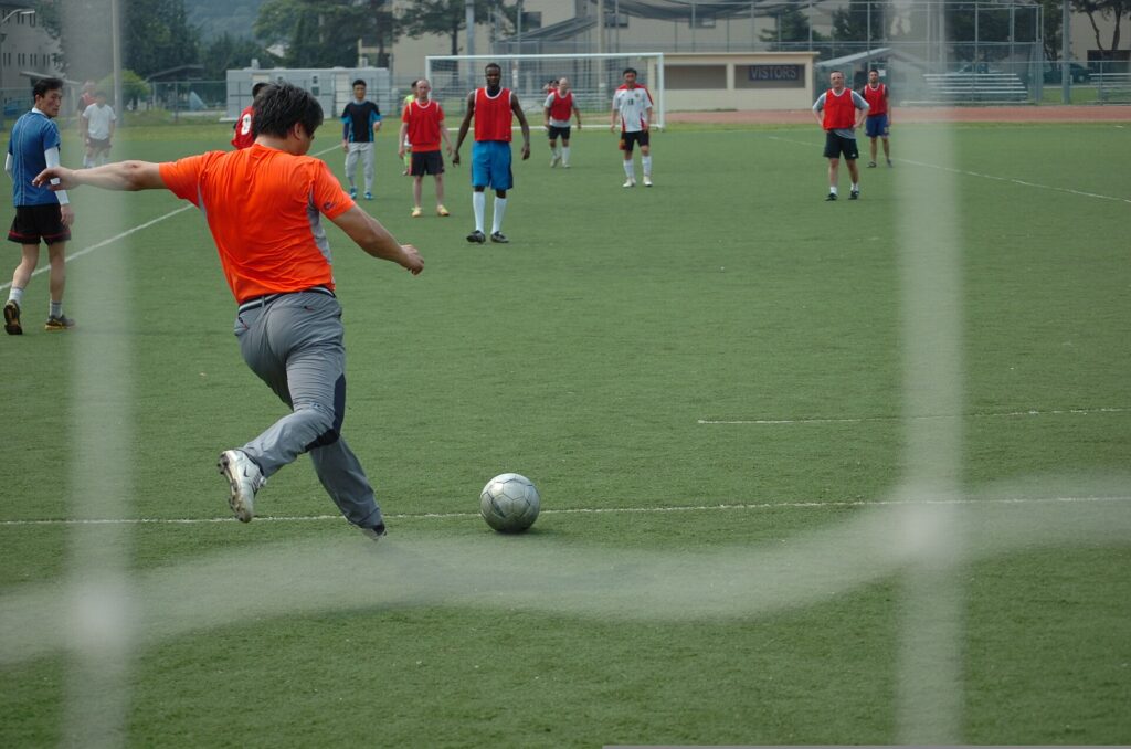A goalkeeper preparing to take a goal kick from the edge of the six-yard box