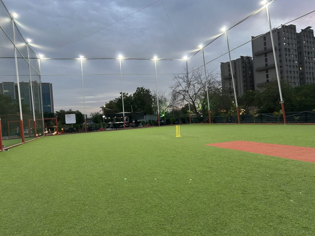 Workers installing floodlight towers at a football stadium under renovation