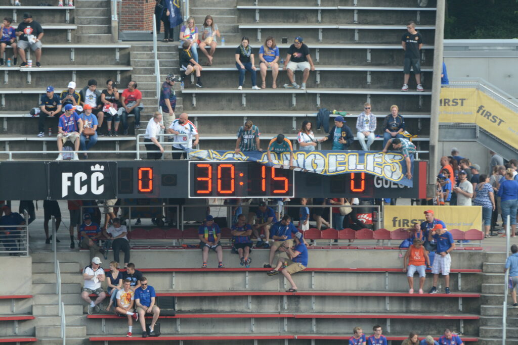 A small block of travelling supporters standing together in an away stadium section