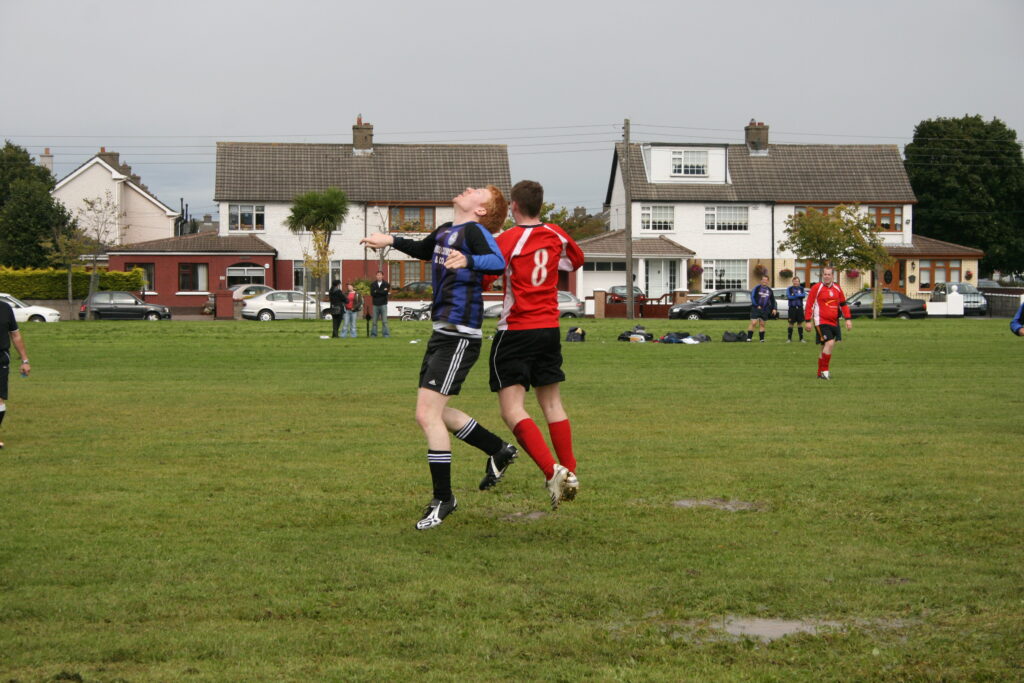 A player rising above defenders to head the ball toward goal from a corner delivery