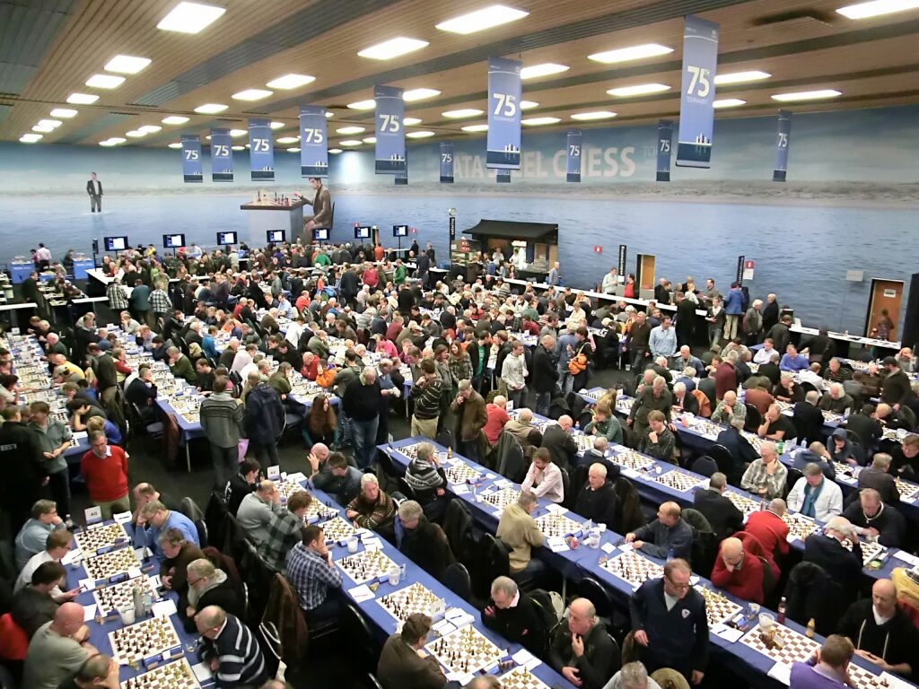 Rows of tables with boards and clocks in a large hall during a chess tournament
